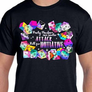 May include: Black t-shirt with a design of colorful dice and the text "Party Members are under ATTACK Roll for INITIATIVE".