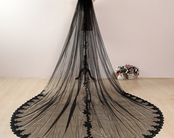 May include: A black tulle wedding veil with a scalloped lace trim. The veil is long and flowing, and the lace trim is delicate and intricate.