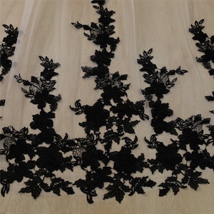 May include: Black lace trim with floral designs on a sheer white fabric.