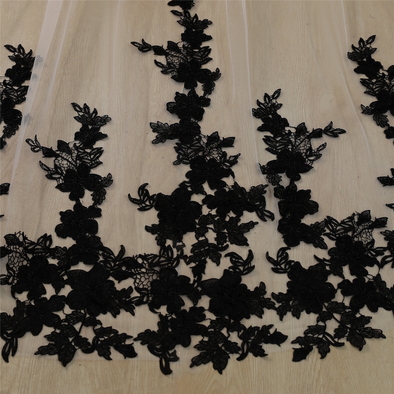 May include: Black lace trim with floral designs on a sheer white fabric.