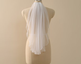May include: A white single-tier bridal veil with a scalloped edge, displayed on a mannequin.