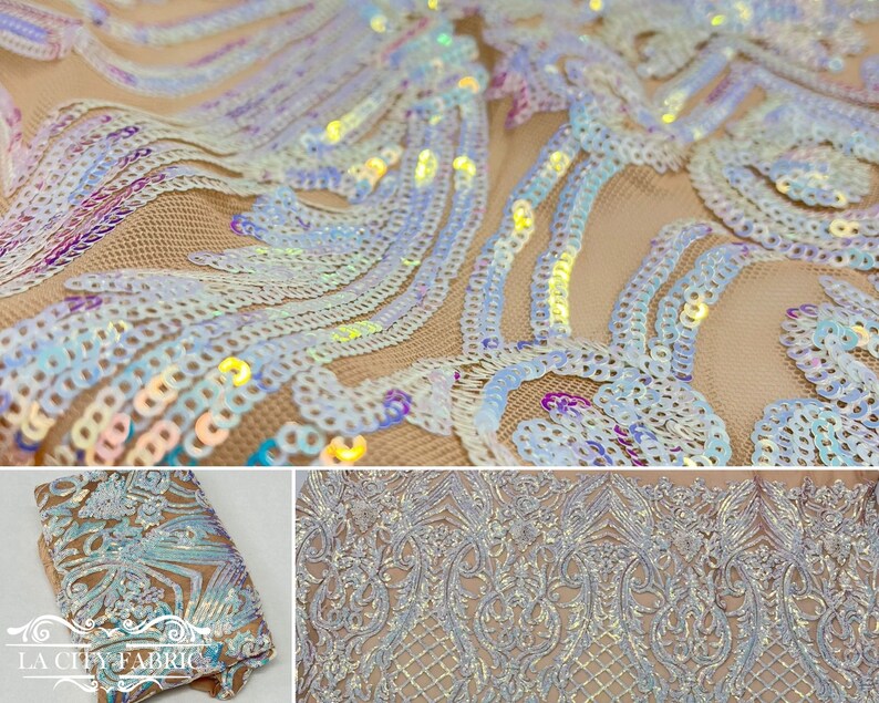 Op de afbeelding: Iridescent witte pailletten op een transparante mesh stof met een bloemenpatroon. De pailletten zijn in een golfpatroon gerangschikt. De stof is beige van kleur.
