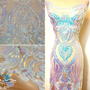 Op de afbeelding: Iridescent blauwe en paarse paillettenstof met een bloemenpatroon op een transparante mesh-basis. De stof is getoond gedrapeerd op een paspop en als close-up.