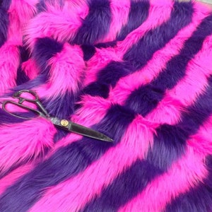 May include: Pink and purple striped faux fur fabric. The fabric is soft and fluffy, and it would be perfect for making a variety of crafts.
