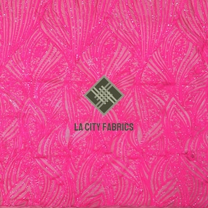 Puede incluir: Tela rosa brillante con un patrón abstracto de lentejuelas. La tela tiene un diseño repetitivo de líneas y formas curvas. Las palabras "LA CITY FABRICS" están impresas en la tela.