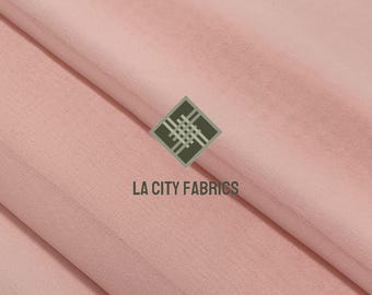 May include: Soft, light pink fabric with subtle folds. The fabric has a smooth texture and a slight sheen. The logo "LA CITY FABRICS" is visible in the lower center of the image.