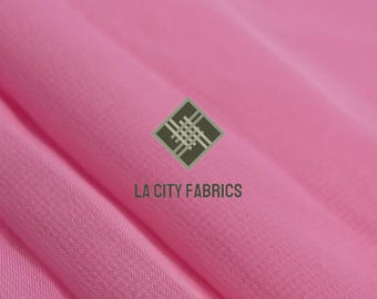 May include: Close-up of a vibrant pink fabric with soft folds. The fabric has a smooth texture and is likely a lightweight material. The logo "LA CITY FABRICS" is visible in the lower center.
