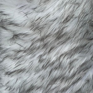 May include: White and black faux fur fabric with a soft, fluffy texture.