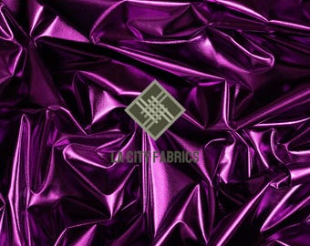 May include: A close-up shot of a crumpled, metallic purple fabric. The material has a shiny surface, creating highlights and shadows. The fabric appears to be suitable for clothing or decorative projects. The logo "LA CITY FABRICS" is visible.