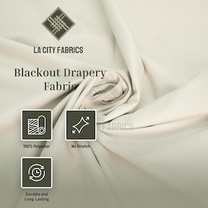May include: Off-white blackout drapery fabric with a smooth texture. Text reads LA CITY FABRICS Blackout Drapery Fabric. Icons indicate 100% Polyester, No Stretch, and Durable and Long Lasting. The fabric is shown in a draped, folded arrangement.