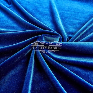 May include: Close-up of a vibrant blue velvet fabric. The fabric is soft and luxurious, with a subtle sheen. LA City Fabric is printed on the fabric.