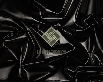 May include: Black, shiny fabric with a reflective surface. The material is heavily wrinkled, creating shadows and highlights. The logo "LA CITY FABRICS" is visible in the lower right corner.