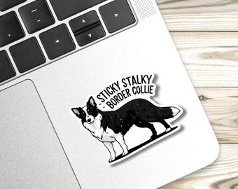 May include: A black and white sticker featuring a Border Collie dog with the text "Sticky Stalky Border Collie". The sticker is on a laptop, with a keyboard visible in the background.