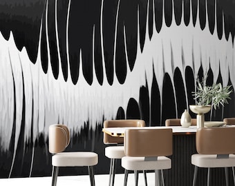 May include: A dining room with a black and white abstract art print on the wall. The room has a modern dining table with a black base and a white top. There are six chairs around the table, all with black legs and brown seats.