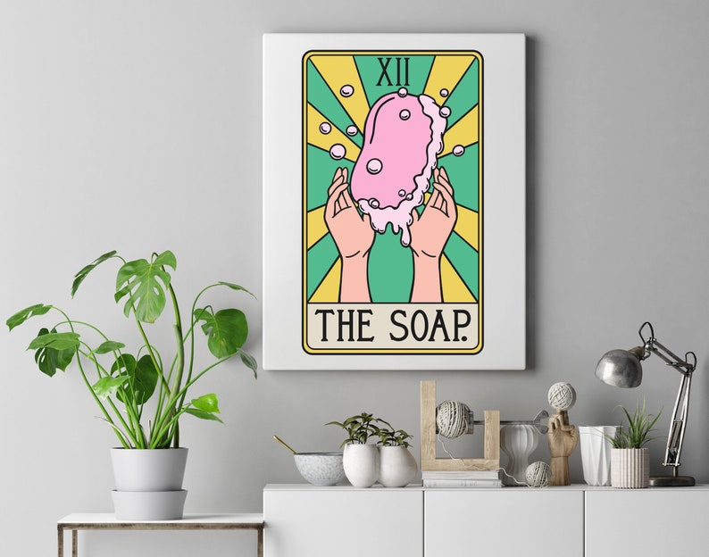 Może przedstawiać: Ilustracja karty tarota z r&oacute;żowym mydłem z bąbelkami, otoczonym ż&oacute;łtymi i zielonymi promieniami. Karta jest oznaczona jako "XII THE SOAP."