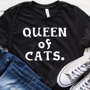 May include: Black t-shirt with white text that reads "QUEEN of CATS."