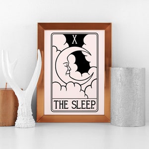 Może przedstawiać: Wydruk w ramie karty tarota z czarno-białą ilustracją rosnącego księżyca z twarzą i chmurami. Karta nosi tytuł "THE SLEEP" i ma rzymską cyfrę "X" w prawym g&oacute;rnym rogu. Rama jest miedziana.