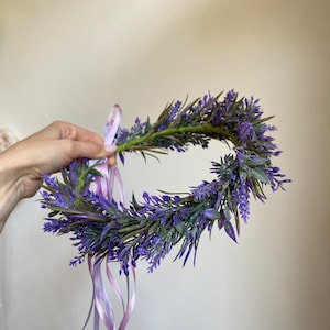 May include: A purple lavender flower crown with a light pink ribbon tied at the back.