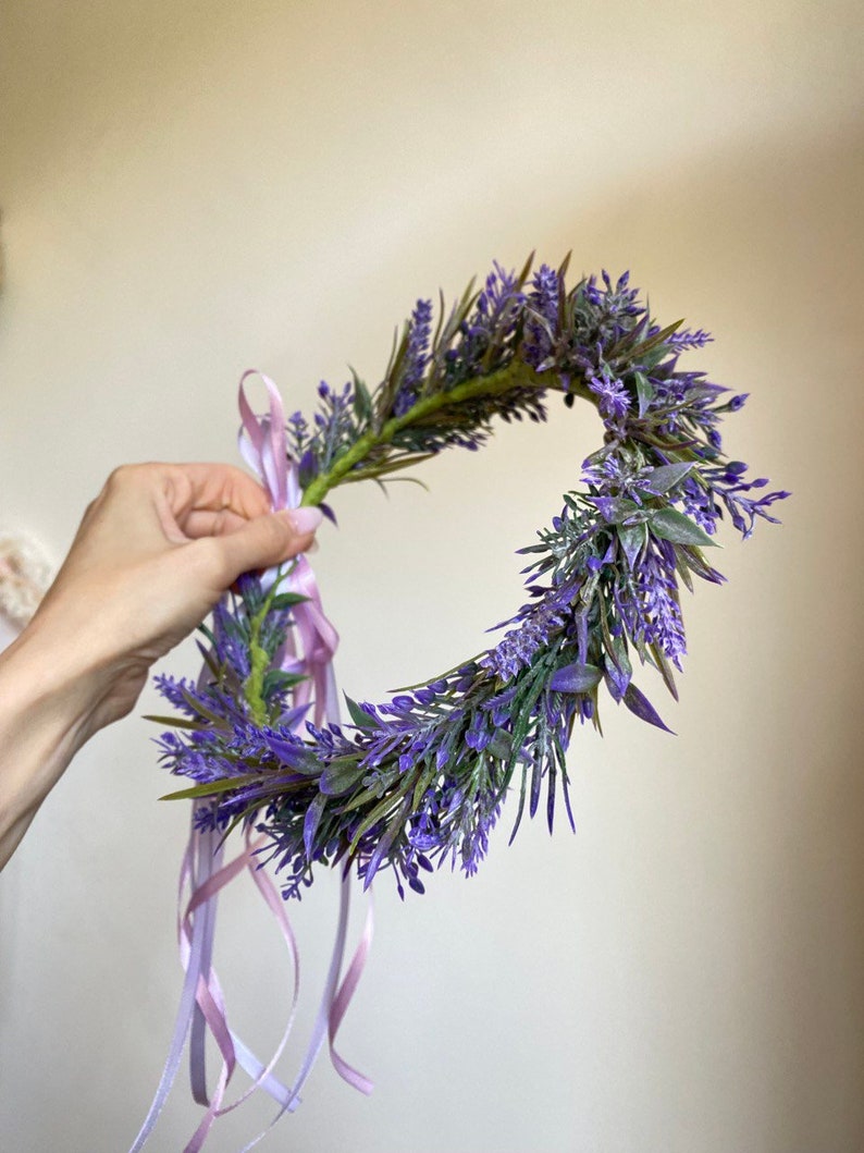 May include: A purple lavender flower crown with a pink ribbon tied around it.