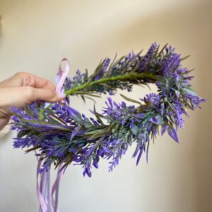 May include: A purple lavender flower crown with a pink ribbon tied around it.