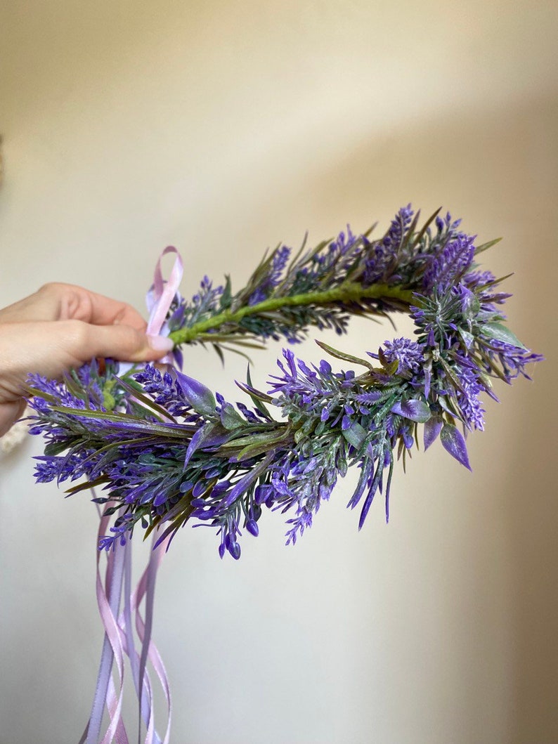 May include: A purple lavender flower crown with a pink ribbon tied around it.