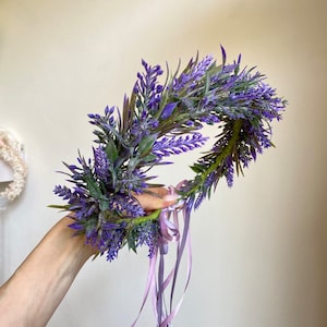 May include: A purple lavender flower crown with long, flowing purple and pink ribbons.