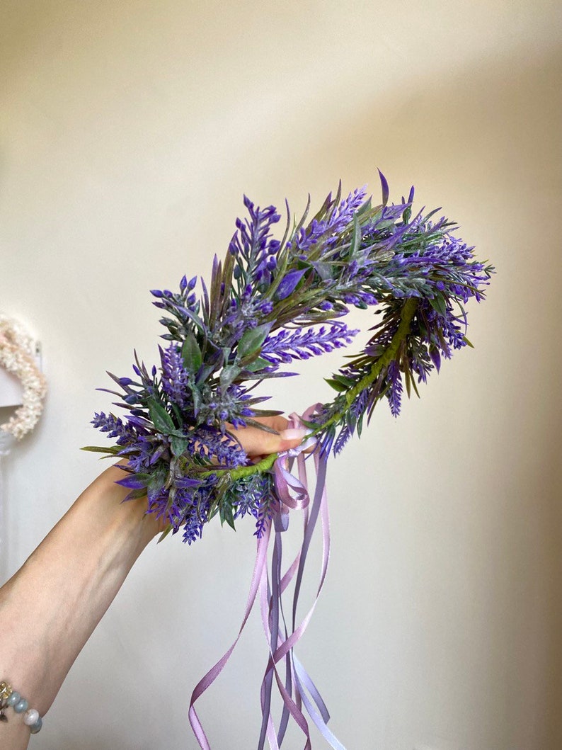 May include: A purple lavender flower crown with long, flowing purple and pink ribbons.