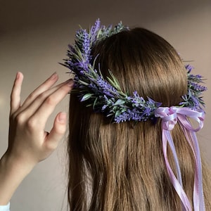May include: A lavender flower crown with a purple ribbon tied at the back. The crown is made of fresh lavender flowers and greenery.