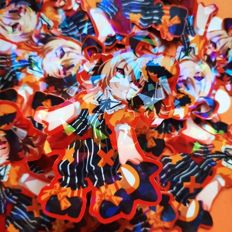 May include: A collection of colorful holographic stickers featuring a cartoon character wearing a black and white striped outfit with a yellow and orange bow. The character has blonde hair and is wearing a black and white hat.
