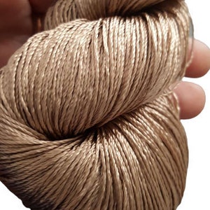 Puede incluir: Una madeja de hilo de seda marrón claro.