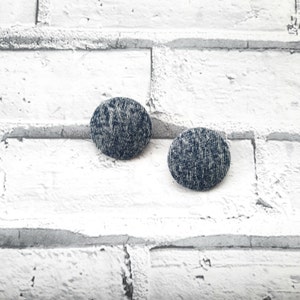 May include: Two round denim fabric buttons with a white background. The buttons are a dark blue color with a white flecked pattern.