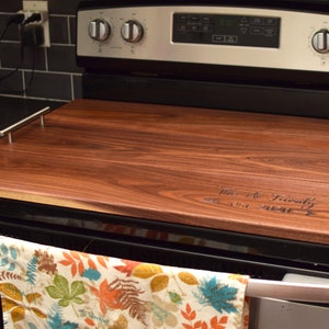 Dark wood stove cover board with handles. Handmade noodle board with handles and monogram. Gas or electric range versions available.