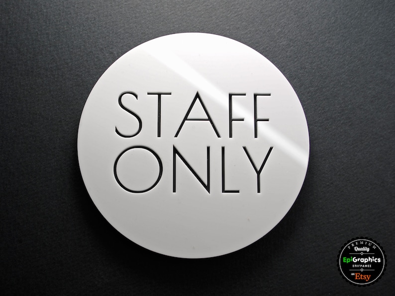 May include: White round sign with black text that reads "STAFF ONLY".