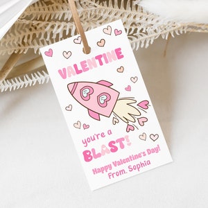 May include: Pink and white Valentine's Day card with a rocket ship illustration and the text "You're a BLAST! Happy Valentine's Day! From, Sophia."