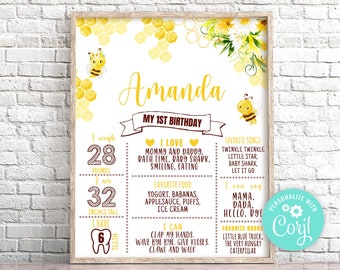May include: A yellow and white printable first birthday milestone poster with a bee theme. The poster features a honeycomb pattern, a bee illustration, and the name "Amanda". It includes details like weight, height, favourite foods, songs, and books. The poster is personalised with the text "Personalize with Coril".