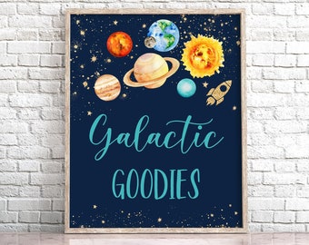 May include: A blue and gold printable sign with a space theme. It features a watercolor illustration of planets, stars, and a rocket ship. The text reads "Galactic Goodies".