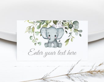 May include: A white card with a watercolor illustration of a gray elephant sitting in a wreath of green leaves. The text "Enter your text here" is printed in gray below the elephant.