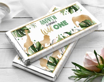 May include: Gold foil chocolate bar wrappers with a green and gold jungle theme. The wrappers feature a giraffe, lion, and elephant with the text "Andrew is turning a Wild One".