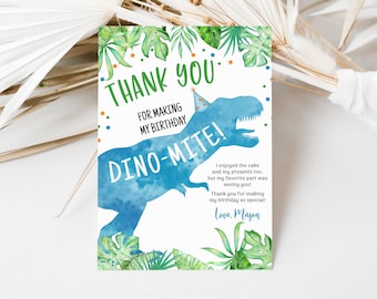 May include: A blue dinosaur with a party hat on its head, surrounded by green leaves. The text "THANK YOU FOR MAKING MY BIRTHDAY DINO-MITE!" is written in green and orange. The text "I enjoyed the cake and my presents too, but my favorite part was seeing you! Thank you for making my birthday so special! Love, Mason" is written in black.