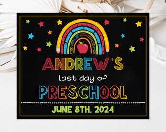 May include: A black chalkboard sign with a colorful rainbow made of pencils and rulers. The sign says "Andrew's last day of Preschool June 8th, 2024".