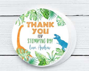 May include: Round thank you sticker with a white background, green tropical leaves, an orange dinosaur, a blue dinosaur, and the text "Thank You for Stomping By! Love, Andrew".