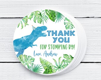 May include: Round thank you sticker with a blue dinosaur wearing a party hat, green tropical leaves, and the text "Thank You for Stomping By! Love, Andrew".
