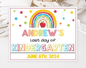 May include: A colorful rainbow with a red apple in the center, surrounded by stars. The text "ANDREW'S last day of KINDERGARTEN" is below the rainbow, with the date "JUNE 8TH. 2024" below the text.