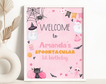 Puede incluir: Un letrero rosa enmarcado de cumpleaños con temática de Halloween. El letrero dice "Welcome to Amanda's Spooktacular 1st birthday" con ilustraciones de fantasmas, murciélagos, un gato negro, calabazas y una telaraña.