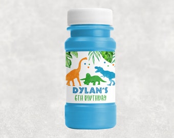 May include: Blue bubble bottle with a white lid and a label that says "Dylan's 6th Birthday". The label has a green, orange, and blue dinosaur design with green leaves.