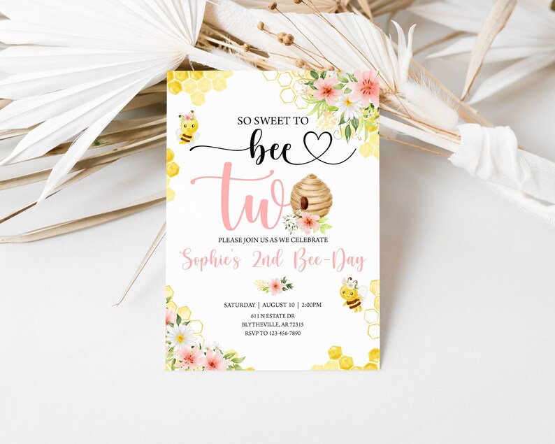 May include: A pink and yellow bee-themed invitation for a second birthday party. The invitation features a beehive with flowers, bees, and honeycomb patterns. The text reads "So sweet to bee two, Sophie's 2nd Bee-Day".