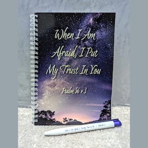 May include: A spiral bound journal with a black cover featuring a galaxy print and the text "When I Am Afraid, I Put My Trust In You - Psalm 56:3".
