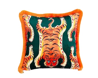 May include: A green throw pillow with a tiger print. The tiger is orange and black with a white background. The pillow has orange fringe around the edges.