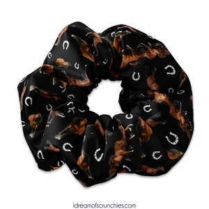 May include: Black scrunchie with a repeating pattern of brown horses and white horseshoes.