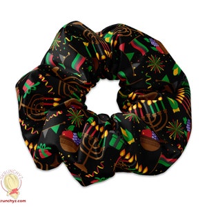 Könnte beinhalten: Schwarzer Scrunchie mit einem Kwanzaa-Muster. Das Muster enthält Kerzen, einen Obstkorb und eine rot-schwarz-grüne Flagge.